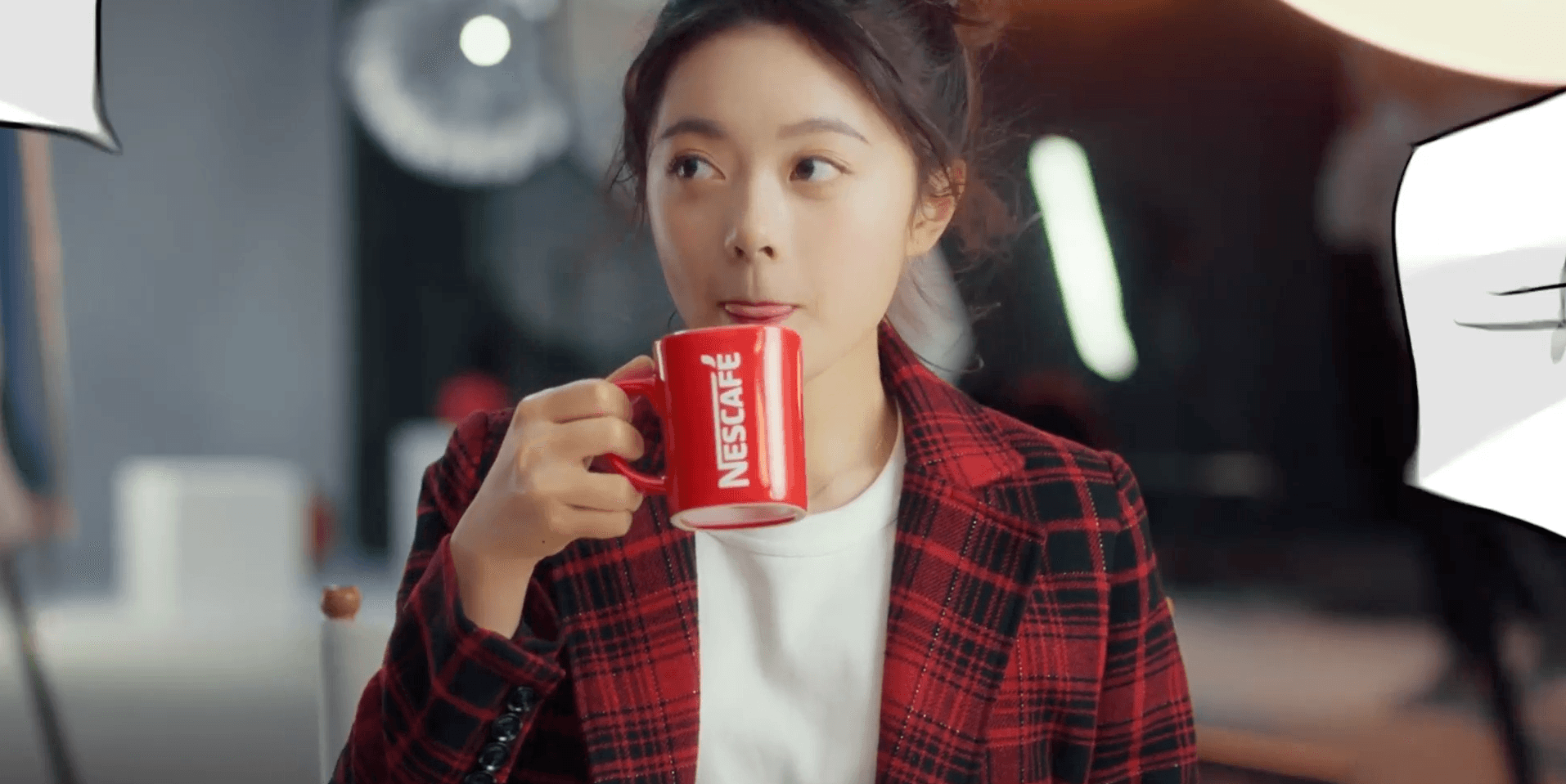 Young woman drinking Nescafé from red mug