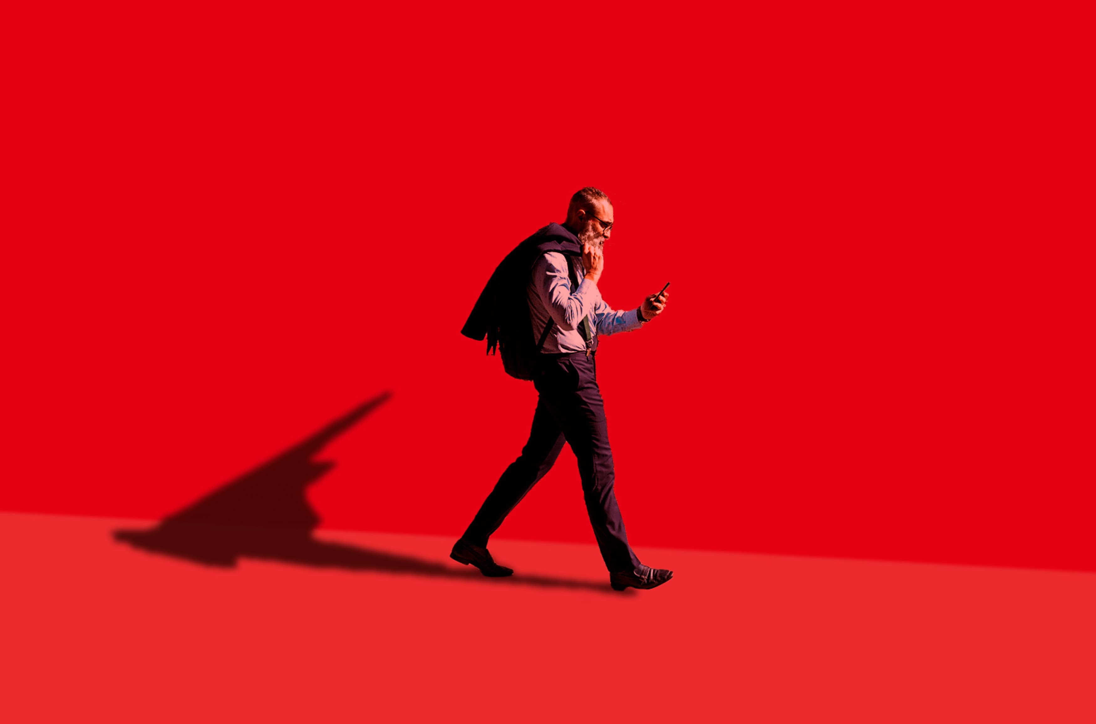 man walking on phone with red background